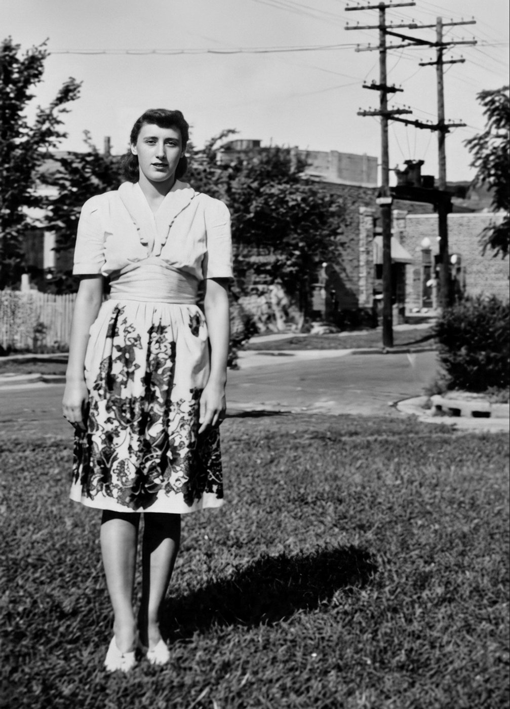 Norma in a floral skirt standing on a lawn